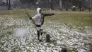 Gabriel Sussman bermain salju turun di taman Zoo Lake di Johannesburg, Afrika Selatan pada 10 Juli 2023. (Wikus de Wet / AFP)