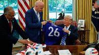Presiden FIFA, Gianni Infantino, memberikan jersey kepada Presiden AS, Donald Trump, selama pertemuan di Oval Office Gedung Putih, Selasa (28/8). Presiden FIFA bertemu Trump untuk membahas kesiapan Piala Dunia 2026. (AP/Evan Vucci)