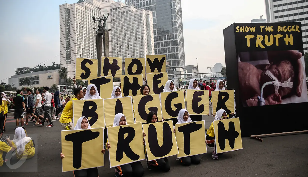 Remaja yang tergabung dalam Smoke Free Agent menggelar aksi damai guna mensosialisasikan bahaya rokok di Bundaran HI, Jakarta, Minggu (5/6). Mereka memberikan peringatan darurat pada pemerintah dalam masalah bahaya rokok. (Liputan6.com/Faizal Fanani)