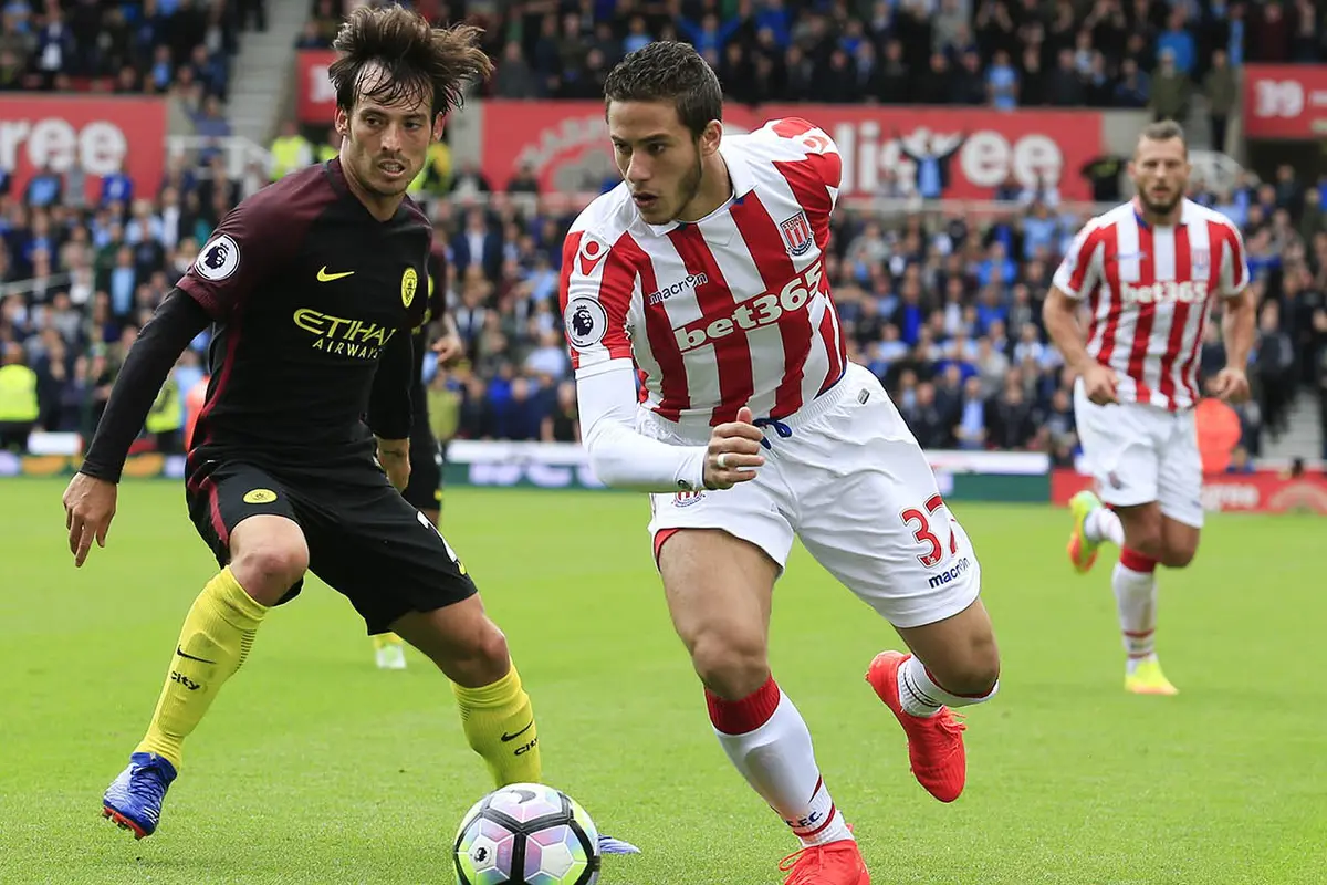 Gelandang Stoke Ramadan Sobhi berusaha melewati playmaker Manchester City, David Silva, pada pertemuan pertama kedua klub di Liga Inggris musim ini.
