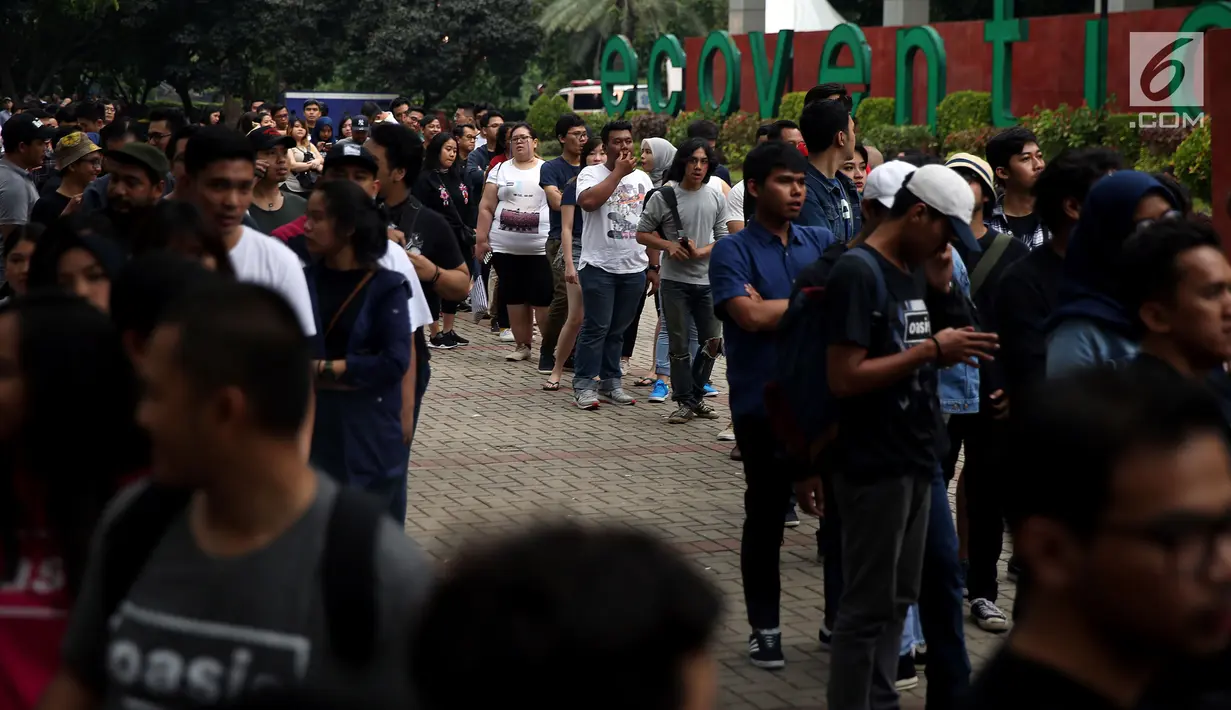 Penonton mengantre tiket masuk konser Liam Gallagher di Ecovention Ancol, Jakarta Utara, Minggu (14/1). Antrean di loket tiket pembelian dan penukaran sudah mulai memanjang sejak sore. (Liputan6.com/JohanTallo)