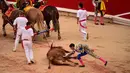 Matador Spanyol Cayetano menyentuh banteng yang mati usai bertarung dalam Festival San Fermin, Pamplona, Spanyol, Jumat (12/7/2019). (AP Photo/Alvaro Barrientos)