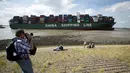 Seorang warga mengabadikan gambar kapal kontainer CSCL Jupiter Hong Kong yang terdampar di muara Westerschelde di dekat kota Bath di Belanda setelah insiden grounding (14/8).  (AFP PHOTO/Belga/Kristof Van Accom/Belgium Out)