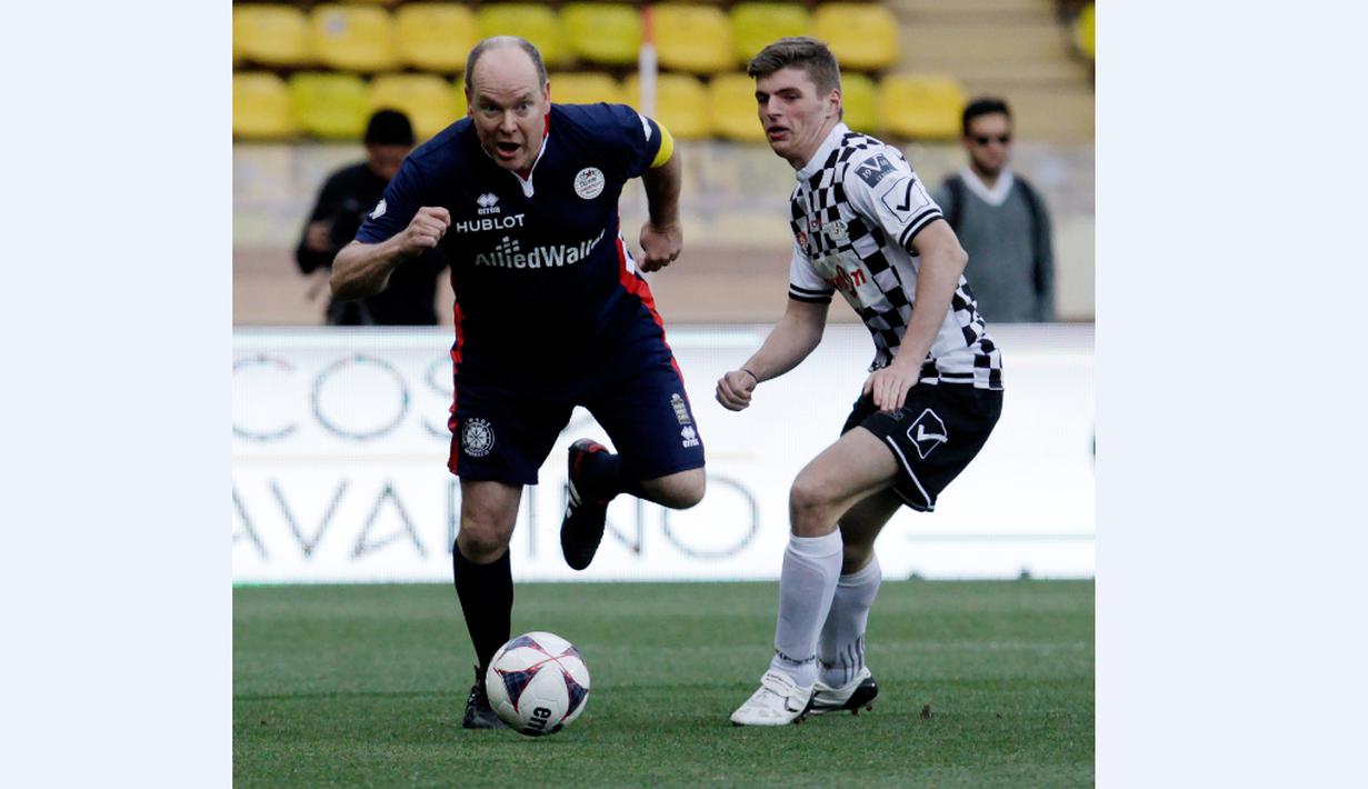 Pangeran Albert II berusaha melewati Max Verstappen dalam laga amal di Stade Louis II Monako, Selasa (24/5/2016). (AFP/Jean Christophe Magnenet)