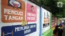 Warga melintas di depan mural yang berisi pesan 3M di Jakarta, Rabu (11/11/2020). Mural tersebut dibuat untuk mengingatkan masyarakat agar menerapkan protokol kesehatan saat beraktivitas sehari-hari. (Liputan6.com/Herman Zakharia)