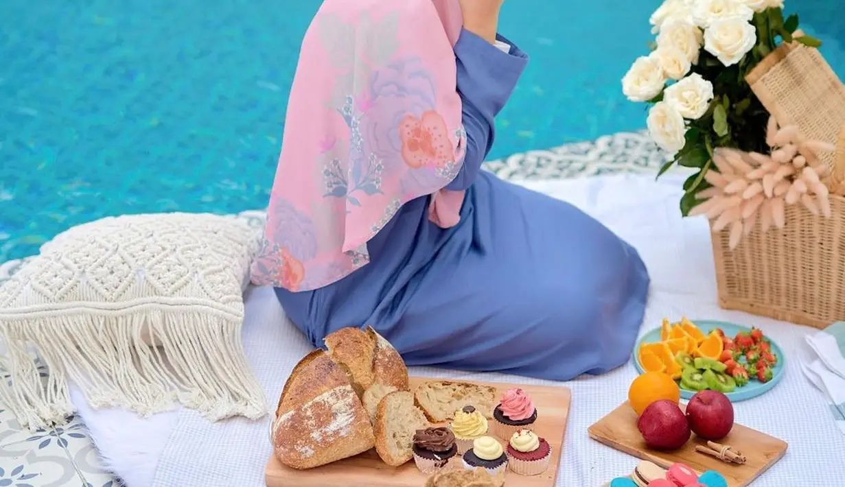 Gamis polos pun akan terlihat menarik jika dipadu padankan dengan hijab yang elevating dan serasi. Dewi Sandra tampil memukau dibalut gamis biru laut polos, dengan padu padan hijab panjang bernuansa merah muda dan bercorak bunga yang manis. [Foto: Instagram/dewisandra]