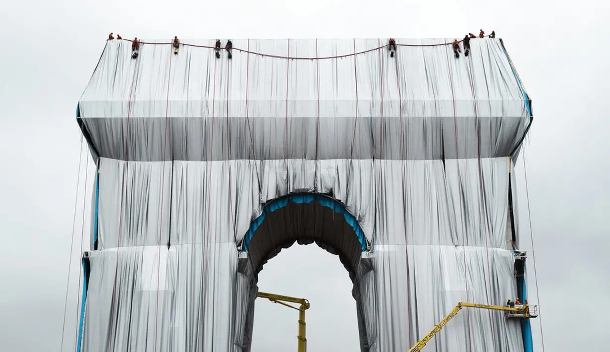 Pekerja membungkus monumen Arc de Triomphe, di Paris pada Selasa (14/9/2021). Monumen bersejarah Paris Arc de Triomphe ditutup plastik daur ulang, sebagai seni instalasi karya seniman Christo dan Jeanne-Claude yang dipamerkan September hingga Oktober 2021. (AP Photo/Thibault Camus)