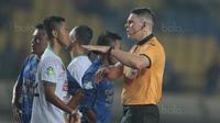 Wasit Evan Shaun Robert memberikan mencoba memberikan penjelasan kepada pemain PS TNI, Sansan Husaeni saat laga melawan Persib Bandung pada lanjutan Liga 1 2017 di Stadion Si Jalak Harupat, Sabtu (05/8/2017). (Bola.com/Nicklas Hanoatubun)