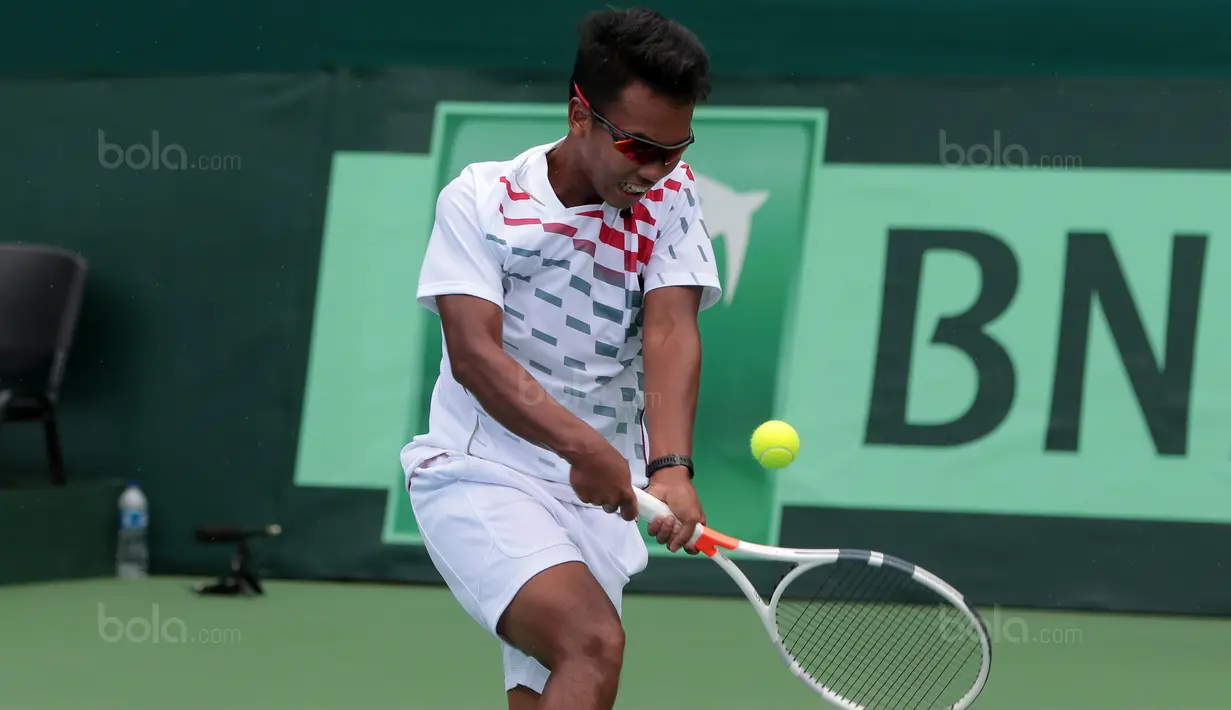 Althaf Dhaifullah mengembalikan bola saat melawan petenis Filipina, Alberto “AJ” Lim Jr. pada Piala Davis 2018 grup dua Asia/Oceania di Senayan, Jakarta, Sabtu (3/2/2018). (Bola.com/Nick Hanoatubun)