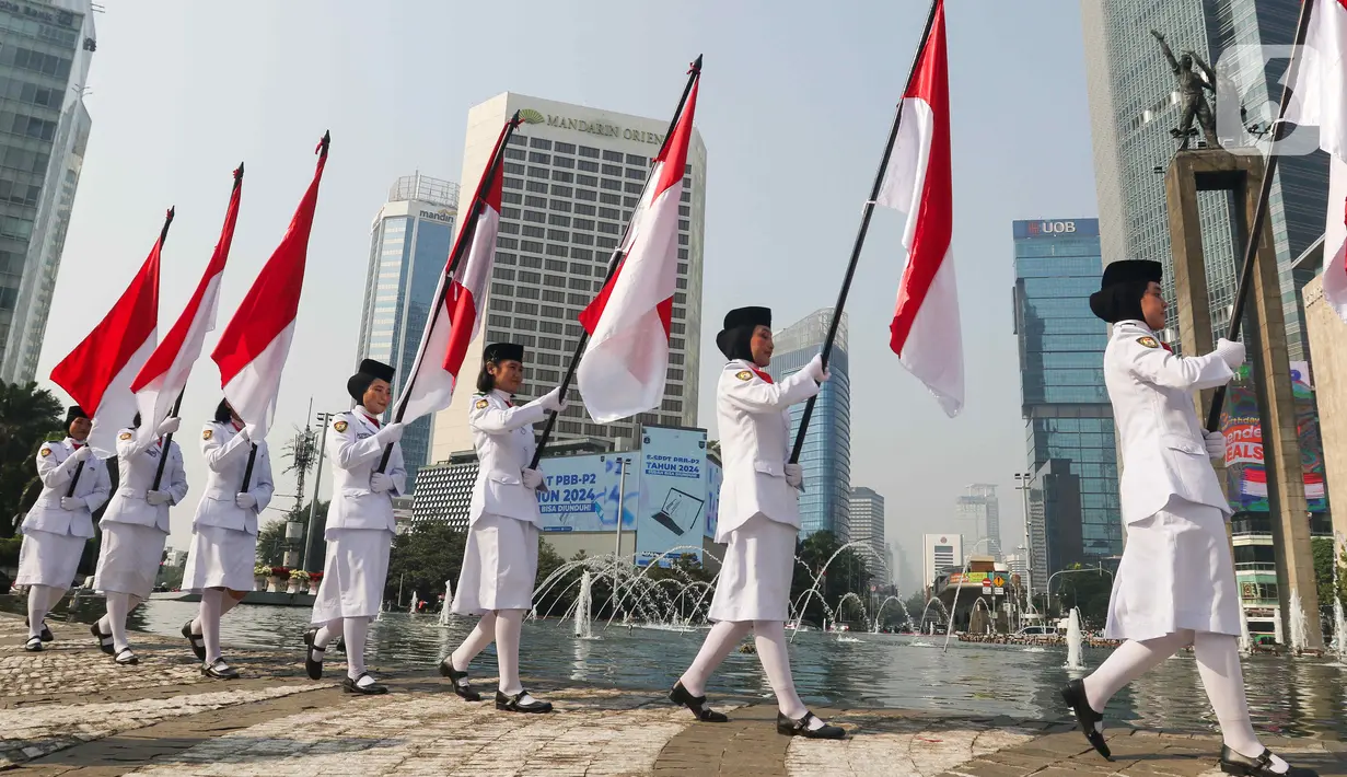Sejumlah pasukan pengibar bendera (Paskibra) berbaris membawa bendera Merah Putih di Bundaran Hotel Indonesia (HI), Jakarta, Kamis (15/8/2024). (Liputan6.com/Herman Zakharia)