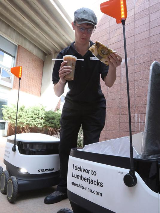 Karyawan rumah makan Michael Sherman menyiapkan makanan untuk diantar oleh robot pengantar makanan di kampus Northern Arizona University, di Flagstaff, Arizona, Amerika Serikat, Selasa (26/3). (Ben Shanahan/Arizona Daily Sun via AP)