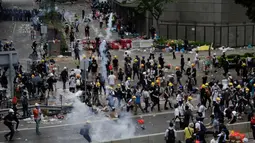 Pengunjuk rasa menghindari gas air mata yang ditembakan oleh polisi anti huru hara di luar gedung Dewan Legislatif, Hong Kong, Rabu (12/6/2019). Polisi Hong Kong telah menggunakan gas air mata ke arah ribuan demonstran yang menentang RUU ekstradisi yang sangat kontroversial. (AP Photo/Vincent Yu)