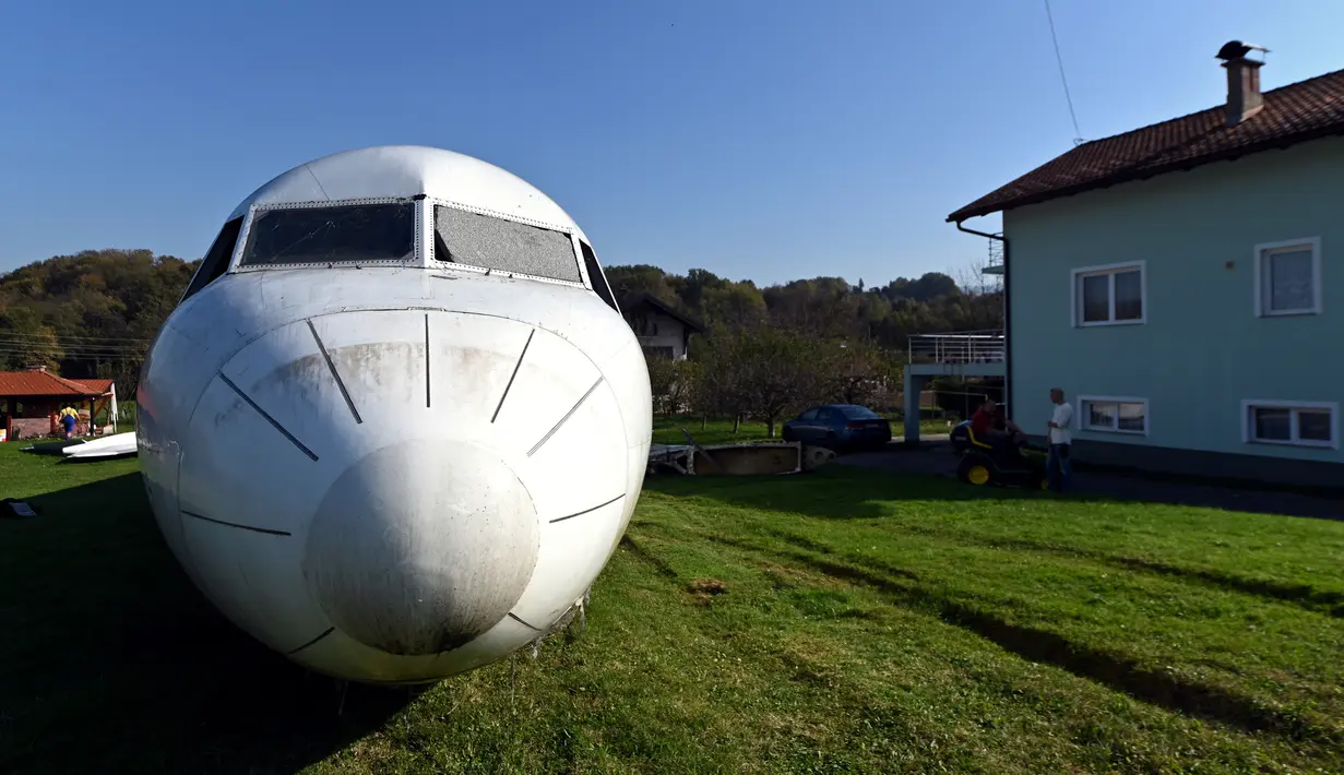 Badan pesawat Fokker-100 terlihat diparkir di halaman rumah warga setempat di Strmec Stubicki, dekat Zagreb, Kroasia, 26 Oktober 2019. Robert Sedlar (50) mengubahnya menjadi objek wisata di mana pesawat bisa disewakan untuk semua jenis acara dan pesta. (Denis LOVROVIC/AFP)