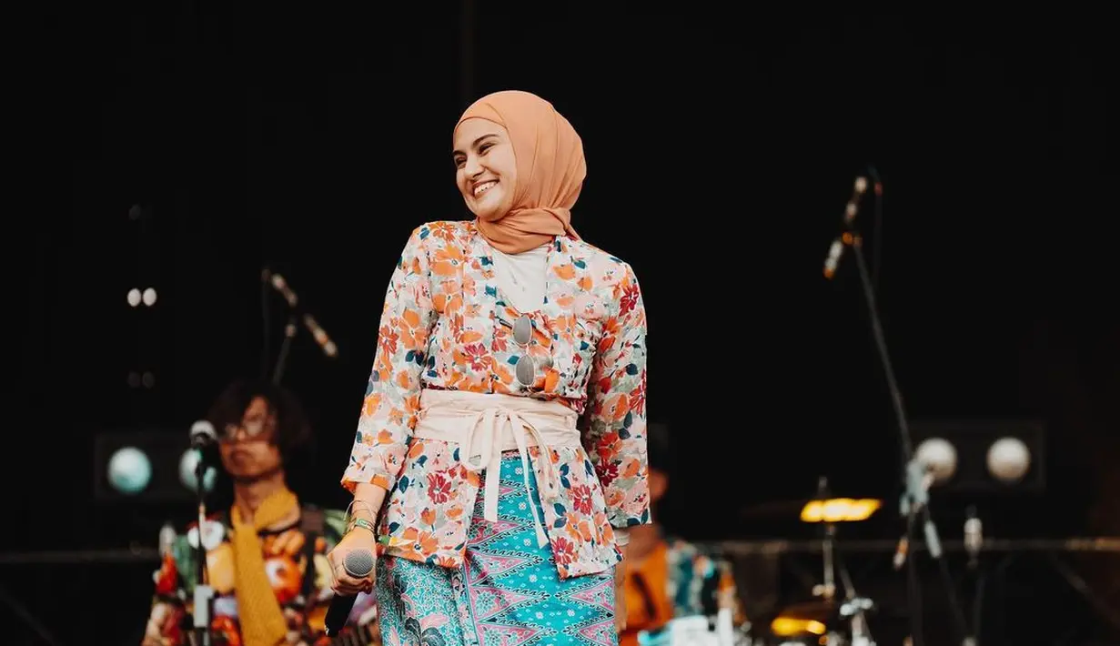 Manisnya penampilan Zee Zee Shahab mengenakan kebaya bercorak floral bernuansa oranye dengan padu padan kain batik biru kehijauan pastel yang serasi. [Foto: Instagram/zeezeeshahab]