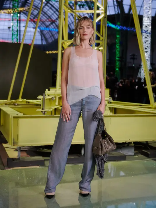 Margot Robbie justru terlihat santai dengan sleeveless top sheer dan straight jeans [Chanel]