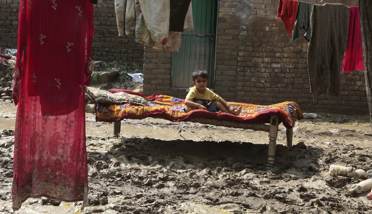 Seorang anak laki-laki berbaring di dipan dekat rumahnya yang dilanda banjir, di Charsadda, Pakistan, Rabu (31/8/2022). Para pejabat di Pakistan menyampaikan kekhawatiran Rabu atas penyebaran penyakit yang ditularkan melalui air di antara ribuan korban banjir saat air banjir dari hujan monsun yang kuat mulai surut di banyak bagian negara. (AP Photo/Fareed Khan)