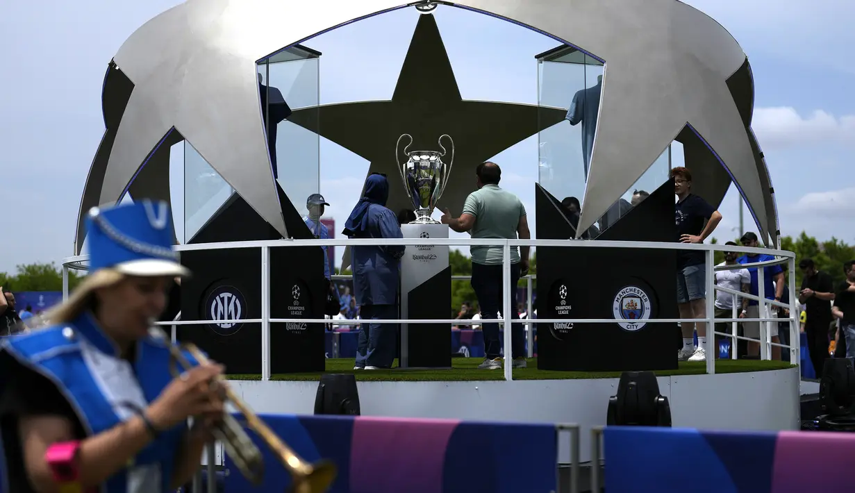 Sejumlah pengunjung berfoto dengan trofi Liga Champions di Istanbul, Turki, Kamis (8/6/2023). Laga final yang mempertemukan Inter Milan melawan Manchester City akan berlangsung di Atatürk Olympic Stadium, Istanbul, Turki, Minggu (9/6/2023) dini hari WIB. (AP Photo/Khalil Hamra)