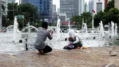 Sejumlah keluarga berfoto bersama di Bundaran Hotel Indonesia (HI), Jakarta, Kamis (1/1/2015). (Liputan6.com/Faizal Fanani)