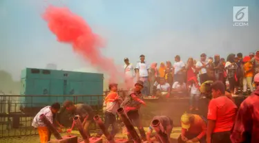 Warga bermain serbuk warna-warni saat colour run dalam Festival Damai Millenial Road Safety di Monas, Jakarta, Minggu (23/6/2019). Serbuk warna-warni yang ditembakkan oleh meriam menambah kemeriahan Festival Damai. (merdeka.com/Iqbal Nugroho)