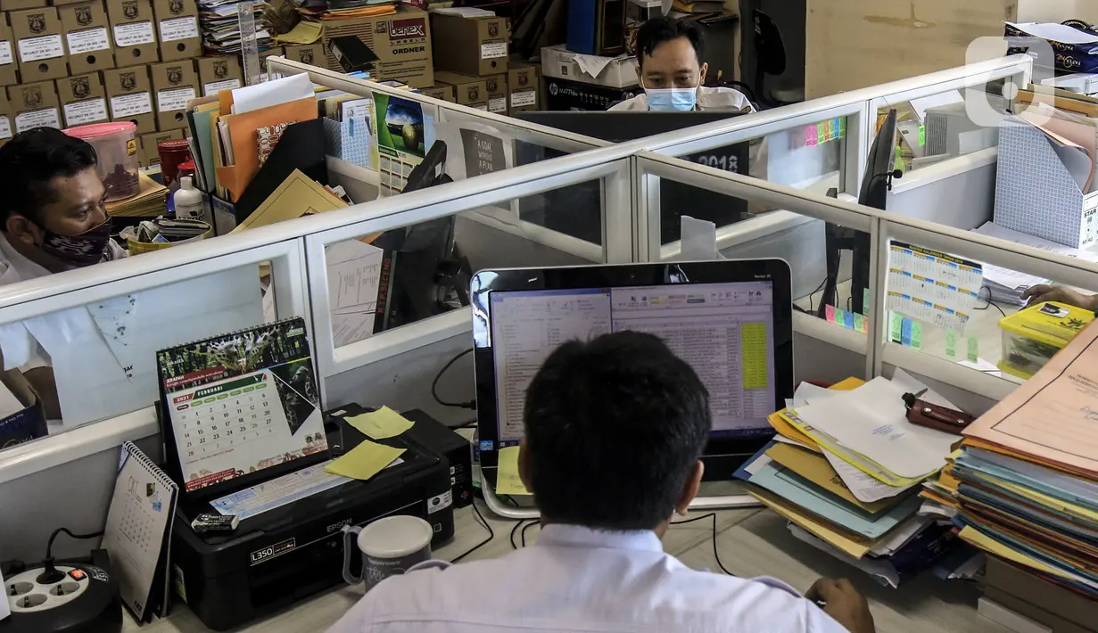 Pegawai Badan Kepegawaian Daerah DKI Jakarta menyelesaikan pekerjaannya di Kantor Balai Kota DKI Jakarta, Kamis (11/2/2021). Kementerian PANRB secara resmi melarang seluruh ASN bepergian ke luar kota saat libur Imlek guna mencegah penyebaran dan penularan COVID-19. (Liputan6.com/Johan Tallo)