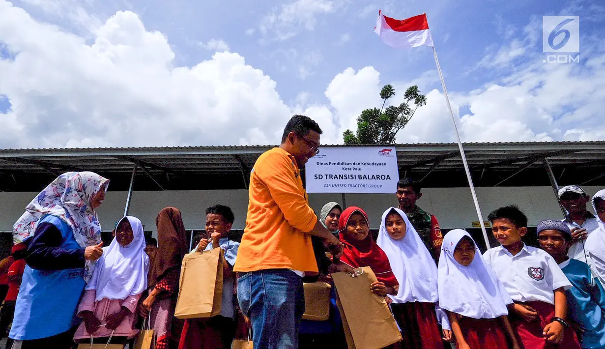 Perwakilan United Tractors memberikan paket peralatan sekolah kepada siswa korban gempa dan tsunami Palu dan Donggala di Balaroa, Sulteng, (16/11). United Tractors telah menyelesaikan pembangunan 4 sekolah sejak bulan Oktober. (Liputan6.com/HO/Eko)