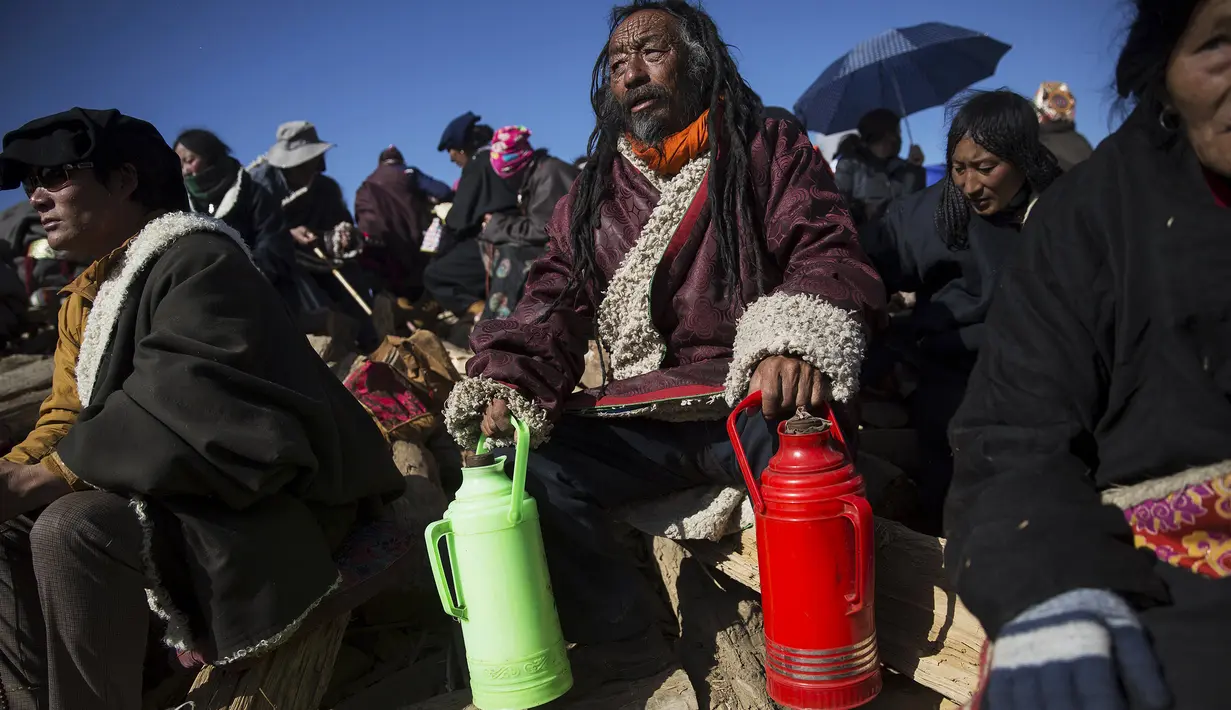 Pria membawa membawa botol isi minuman untuk persiapan perjalanannya ke Larung Wuming Buddha Institute, Tibet, Cina (1/11/2015). Ribuan orang berkumpul untuk berdoa dan bernyanyi selama ikuti Utmost Bliss Dharma. (REUTERS/Damir Sagolj)