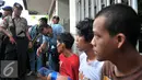 Petugas berbincang dengan warga yang diduga bandar narkoba dan terlibat pengeroyokan di kampung Berlan, Jakarta, Kamis (21/1). Aparat gabungan lakukan penggeledahan dan mencari pelaku tersangka pengeroyokan di kampung Berlan. (Liputan6.com/Yoppy Renato)