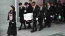 Kakak Jonghyun berjalan di depan pada pelepasan jenazah member boyband SHINee tersebut menuju tempat pemakaman dari Asan Hospital, Seoul, Kamis (21/12). Para member SHINee dan Super Junior mengangkat peti Jonghyun menuju mobil jenazah. (JUNG Yeon-Je/AFP)