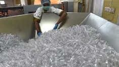 Pekerja mengecek botol di pabrik air mineral alami Aava di Ahmedabad, India (19/3). Hari Air Sedunia jatuh pada tanggal 22 Maret dan berfokus pada pentingnya akses universal terhadap air bersih, sanitasi dan fasilitas kebersihan. (AFP Photo/Sam Panthaky)
