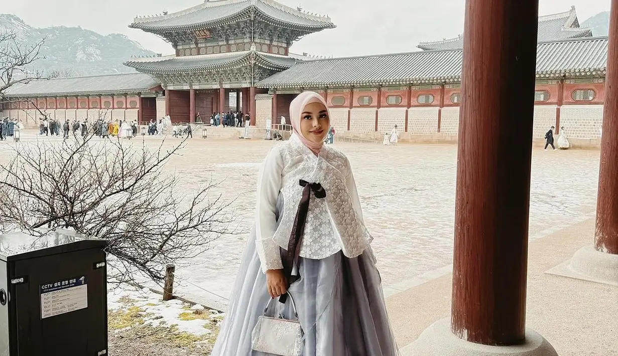 Aurel Hermansyah terlihat memadukan hanbok warna putih-abu-abunya dengan hijab segi empat warna baby pink. Penampilannya itu disempurnakan dengan pulasan makeup bold khasnya. [@attahalilintar]