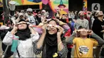 Pengunjung mengamati gerhana matahari cincin memakai kacamata khusus di Planetarium Taman Ismail Marzuki, Jakarta, Kamis (26/12/2019). Planetarium menyediakan sekitar 10 teleskop dan kacamata khusus agar pengunjung bisa menyaksikan gerhana matahari cincin dengan aman. (Liputan6.com/Faizal Fanani)