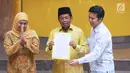 Plt Ketua Umum Partai Golkar, Idrus Marham (tengah) bersama Khofifah Indar Parawansa (kiri) dan Emil Elistyanto Dardak menunjukkan surat rekomendasi Cagub dan Cawagub Jawa Timur pada Pilkada 2018 di Jakarta, Rabu (22/11). (Liputan6.com/Helmi Fithriansyah)