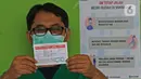 Seorang tenaga medis menunjukkan status pemberian vaksin CoronaVac di Rumah Sakit JatiSampurna, Bekasi, Jawa Barat, Kamis (28/01/2021). RS JatiSampurna melakukan Penyuntikan dosis kedua vaksin COVID-19 untuk para tenaga medis dan tenaga kesehatan yang bertugas. (Liputan6.com/Herman Zakharia)