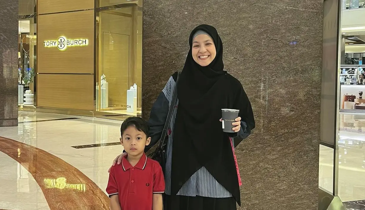 Hangout dengan anak ala Natasha Rizky. Penampilannya menarik dengan oversized shirt, rok hitam, dan hijab panjang hitam. [Foto: Instagram/natasharizkynew]