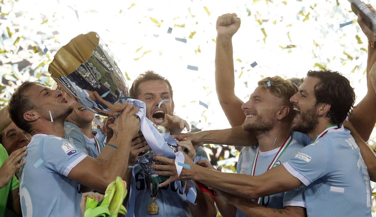 Para pemain Lazio mengangkat trofi Supercoppa Italiana 2017 usai berhasil mengalahkan Juventus di Stadion Olimpico, Minggu, (13/8/2017). Lazio menang 3-2 atas Juventus. (AP/Gregorio Borgia)