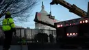 Para pekerja memperkuat pagar pengendali massa di sekitar Capitol Hill AS, Washington D.C, dengan penghalang beton sehari setelah peristiwa kericuhan Kamis (7/1/2021). Peristiwa penyerbuan di gedung Capitol Hill AS dilakukan oleh massa pendukung Donald Trump pada 6 Januari. (Brendan Smialowski/AFP)