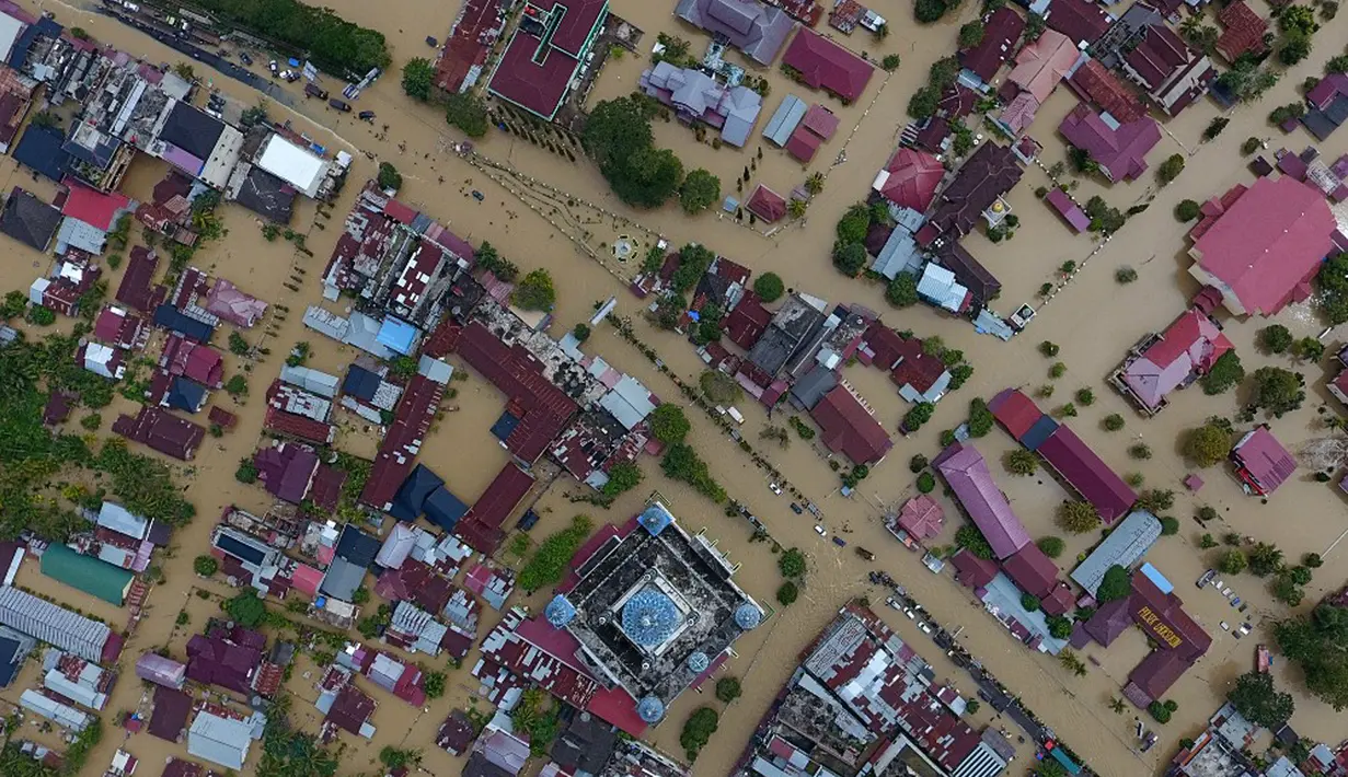 Foto udara menunjukkan bangunan, termasuk masjid (tengah bawah), terendam banjir di Lhoksukon, Aceh Utara, Aceh, 3 Januari 2022. Ketinggian air banjir di Lhoksukon mencapai dada orang dewasa. (ZIKRI MAULANA/AFP)