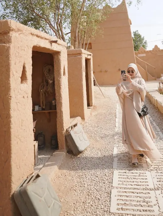 Saat liburan, Dinda Hauw memakai pakaian berwarna coklat senqda dengan hijab. Dia juga mengenakan sunglesses