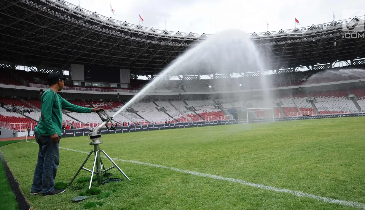 Pekerja menyemprot rumput lapangan Stadion Gelora Bung Karno pasca renovasi, Jakarta, Jumat (12/1). Rencananya, Stadion GBK akan diresmikan penggunaannya pasca renovasi oleh Presiden Joko Widodo, Minggu (14/1). (Liputan6.com/Helmi Fithriansyah)