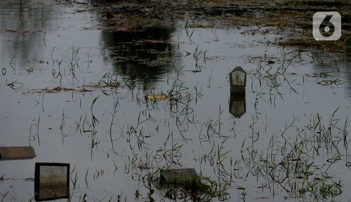 Sejumlah makam di Tempat Pemakaman Umum (TPU) Tanah Kusir terendam banjir, Jakarta, Jumat (3/1/2020). TPU Tanah Kusir terendam banjir setelah Kali Pesanggrahan meluap akibat intensitas hujan  yang tinggi pada Rabu lalu. (merdeka.com/Imam Buhori)