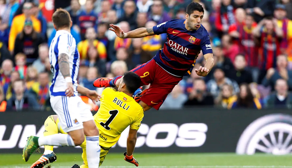 Luis Suarez berduel dengan kiper Real Sociedad, Geronimo Rulli, dalam lanjutan La Liga Spanyol di Stadion Camp Nou, Barcelona, Sabtu (28/11/2015). (EPA/Alejandro Garcia)