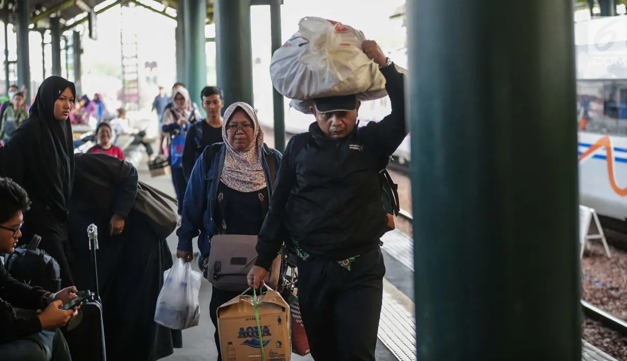 Pemudik mengangkat barang bawaan mereka setibanya dI Stasiun Gambir, Jakarta, Minggu (9/6/2019). Pada H+4 Lebaran yang merupakan puncak arus balik lebaran, sebanyak 78.249 orang tiba di Jakarta melalui Stasiun Gambir sejak 6 Juni 2019 sampai dengan hari ini. (Liputan6.com/Faizal Fanani)