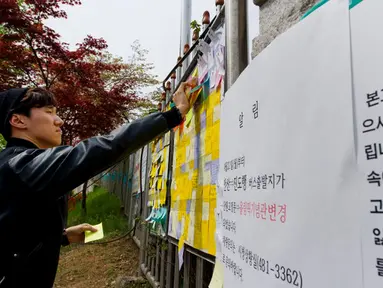 Beberapa pesan untuk mengenang para korban tenggelamnya kapal feri Sewol ditempelkan di gerbang utama Ansan Danwon High School, Korea Selatan, Senin (21/4/2014). (AFP PHOTO/KIM DOO-HO)