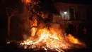 Seorang  penunggang kuda melompati api unggun selama festival Luminarias di San Bartolome de Pinares, Spanyol, Rabu (16/1). Ritual membara ini pun didampingi oleh seorang pastor dan dua saksi yang memberkati para binatang. (GABRIEL BOUYS / AFP)