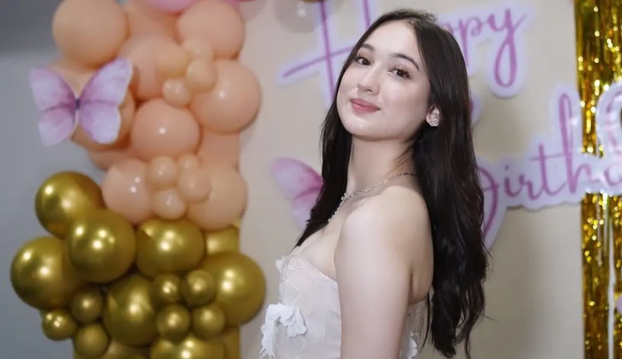 Wajah dipoles makeup bernuansa coklat yang cocok di warna kulit putihnya. Mengaplikasikan lipstik coklat nude dengan blush on tipis. Rambut panjang tanpa poni dibiarkan terurai. [@its_lauraamoane]