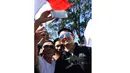 Antusias Fans Indonesia saat bertemu Rio Haryanto dan berfoto selfie bersama sebelum balapan perdana Formula One Australian Grand Prix, Melbourne, Minggu (20/3/2016). (AFP/Paul Crock)