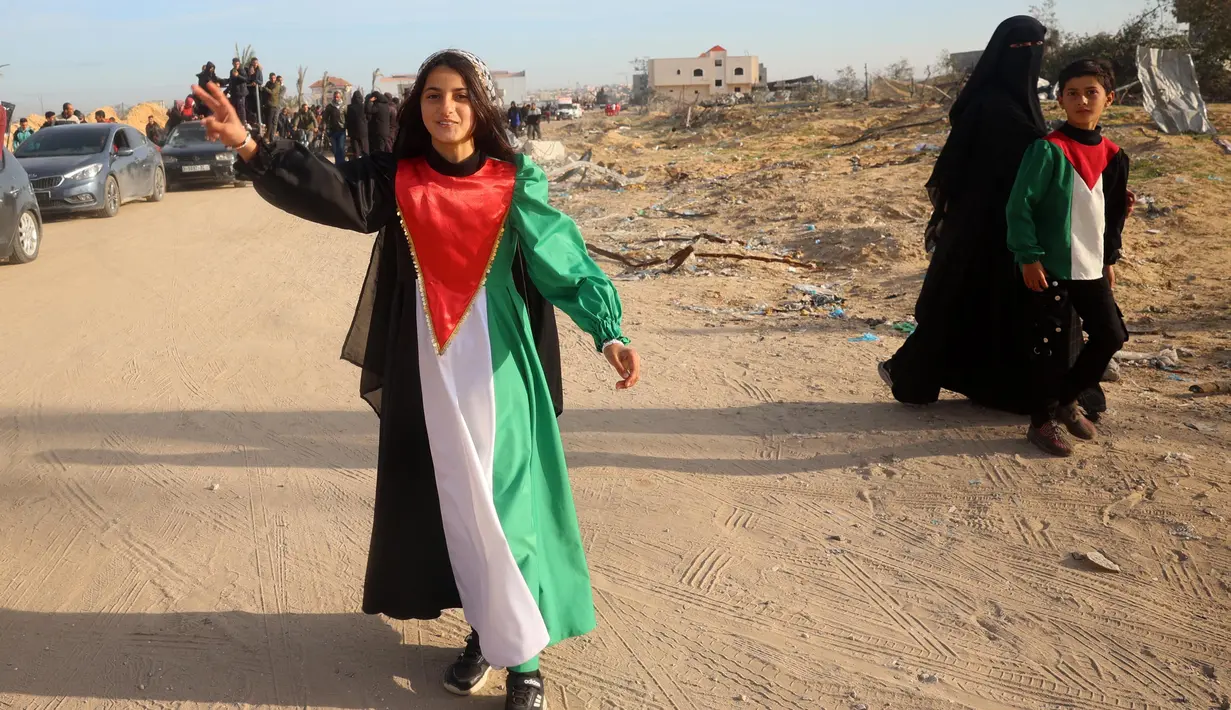 Seorang perempuan muda mengenakan gaun dengan warna bendera Palestina saat orang-orang kembali ke Rafah, Jalur Gaza selatan pada 19 Januari 2025. (Eyad BABA/AFP)