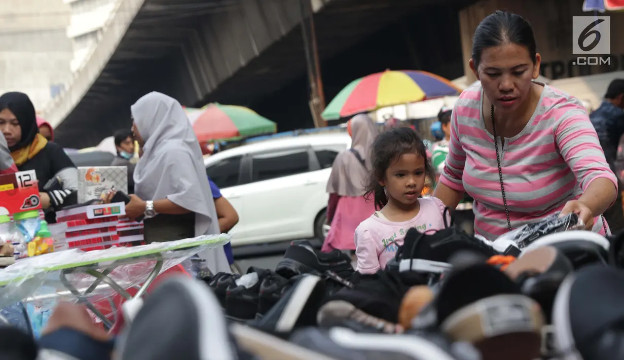 Seorang ibu bersama anaknya memilih sepatu di Pasar Asemka, Jakarta, Selasa (7/9/2019). Jelang dimulainya tahun ajaran baru, Pasar Asemka ramai dikunjungi warga untuk berbelanja keperluan sekolah. (Liputan6.com/Helmi Fithriansyah)