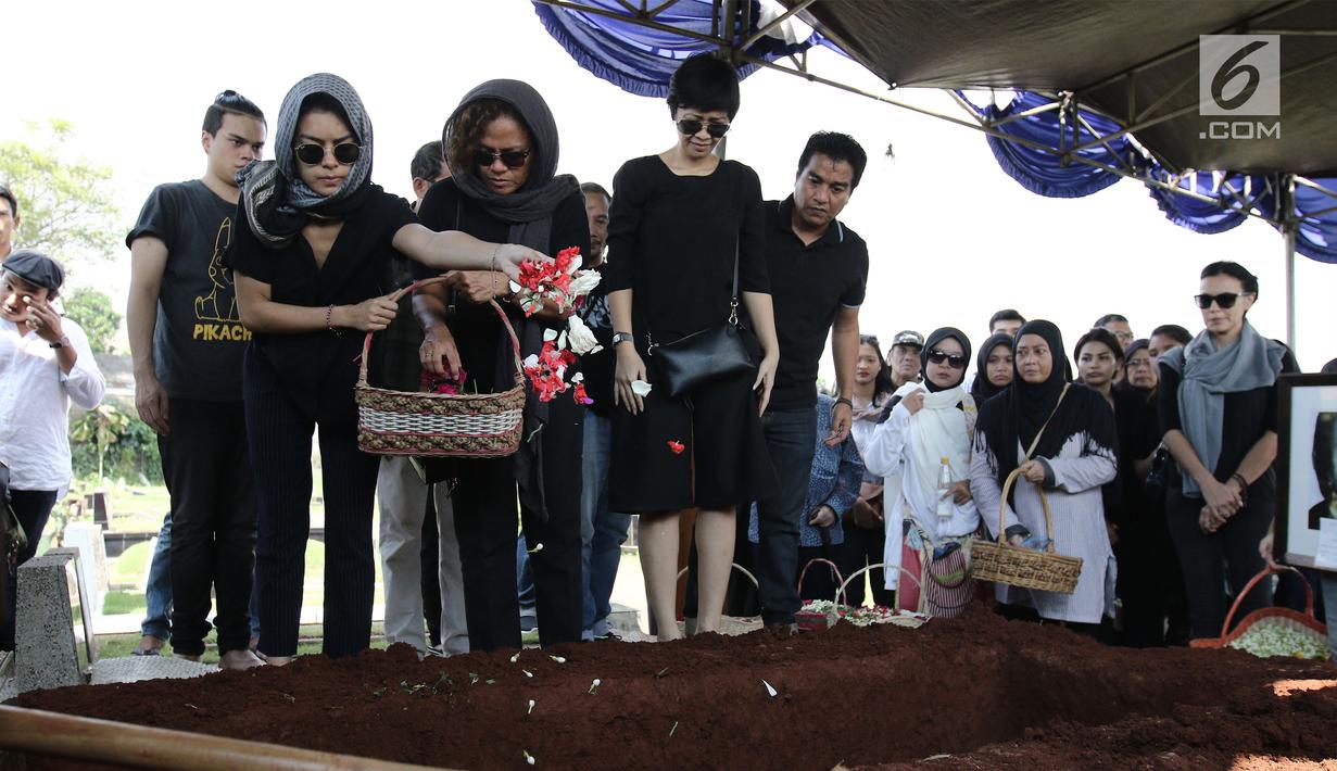 Eva Celia menaburkan bunga di pemakamanya neneknya, Nien Lesmana di TPU Tanah Kusir, Jakarta, Rabu (28/6). Ibu dari Indra Lesmana dan Mira Lesmana meninggal dunia pada usai 88 tahun. (Liputan6.com/Herman Zakharia)