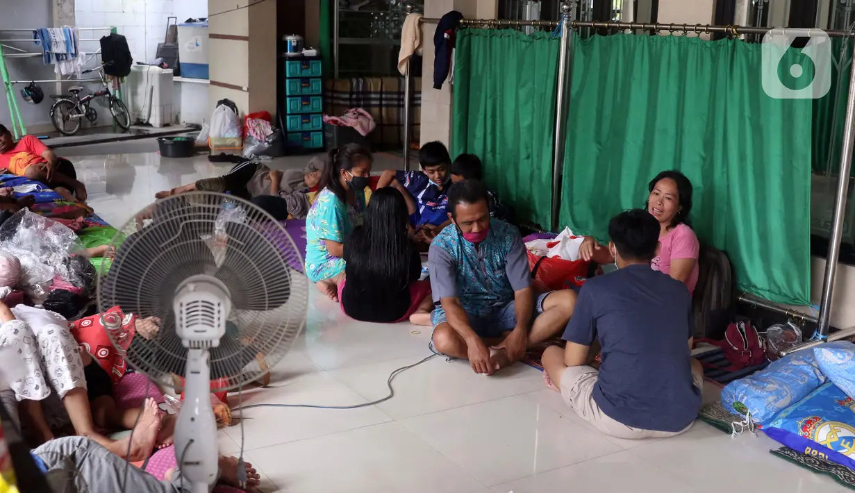 Aktivitas warga saat mengungsi di halaman Masjid Jami Al-Jihad, Perumahan Periuk Damai, Tangerang, Banten, Selasa (23/2/2021). Banjir setinggi 2,5 meter membuat warga harus mengungsi di tempat yang aman. (Liputan6.com/Angga Yuniar)